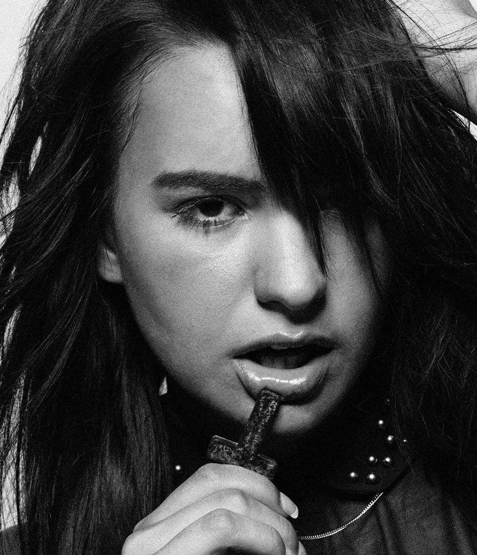 girl biting cross necklace